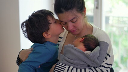 Older boy kissing both mother and newborn baby, creating a tender and heartwarming family moment filled with love and connection, highlighting the bond between siblings and mother-SD 480p