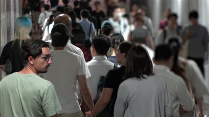 TOKYO, JAPAN - AUG 2025 : Time lapse shot of crowd of people walking at busy downtown area in busy night rush hour. Japanese people, urban city life and lifestyle concept video.