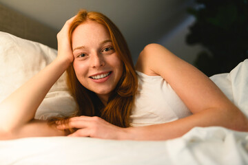 Obraz premium Young redhead woman on bedroom at home