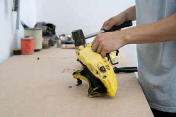 A skilled car mechanic works on a brake caliper in a well-equipped workshop. Using pliers, the technician carefully performs repairs to maintain vehicle functionality.