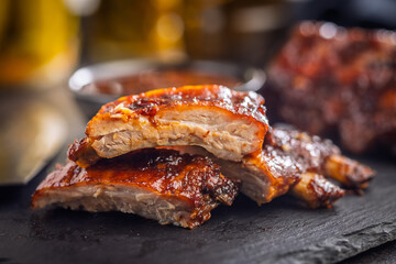 Pork BBQ glazed ribs on black table.