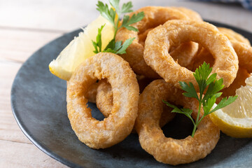 Crispy fried squid rings on wooden table