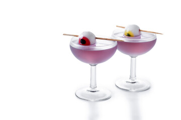 Purple Halloween cocktail garnished with candy eye isolated on white background. Copy space