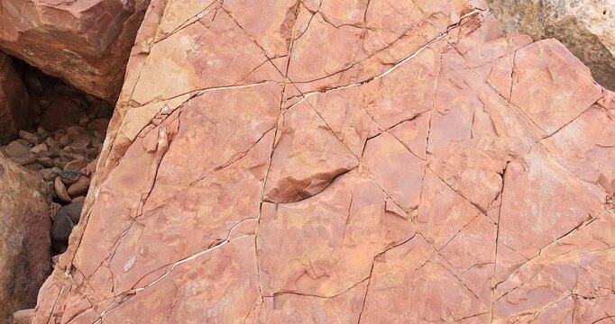 Gimbal pull back movement on brown and pink color flat rock with extensive erosion crack pattern on surface 4k
