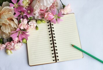 Notebook and flowers on white background, space for add text.