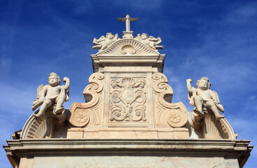 Elvas, Portugal. Early 18th Century, marble Baroque religious architectural detail with intricate sculptures of child angels, shells and a cross. 
