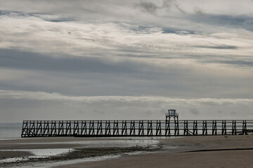 la jet&eacute;e de Luc-sur-Mer sous un ciel gris
