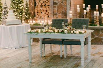Elegant dining setup for a cozy winter celebration with greenery and candlelight accents