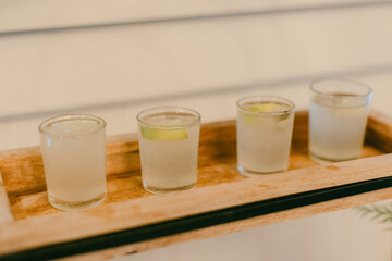Group of four elegant cocktails served on a wooden tray at a cozy bar during an evening gathering