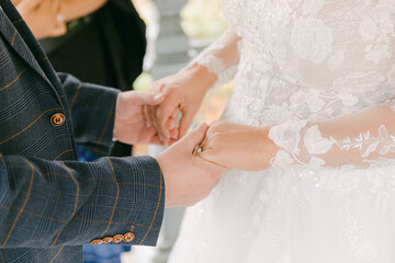 Couple exchanging rings during intimate wedding ceremony in a beautiful garden setting