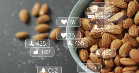 Displaying ceramic bowl holding almonds on dark countertop, with social media icons, copy space