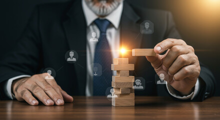 Experienced leader carefully builds team structure with wooden blocks and glowing success.