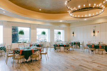 Elegant dining space with decorated tables and natural lighting during a special event in a modern...