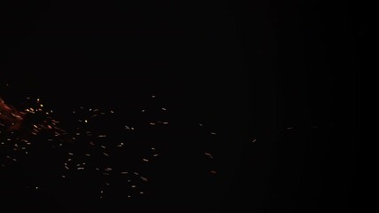Slow motion vertical shot of fire and sparks and embers from campfire flying over black background - Powered by Adobe