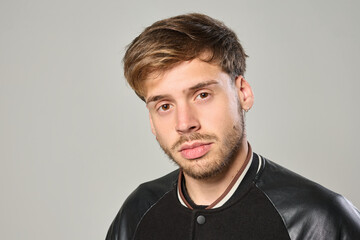 Fototapeta premium Close-up portrait of young Caucasian man with piercing looking serious in studio