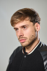 Obraz premium Close-up of young Caucasian man with earring and intense gaze in studio with white background