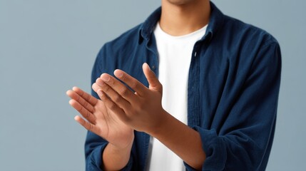A young man claps softly, expressing appreciation and joy. The image captures a casual moment of celebration. Ideal for motivational and uplifting themes. AI