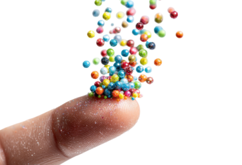 Colorful, small, spherical candies or sprinkles are erupting from a fingertip