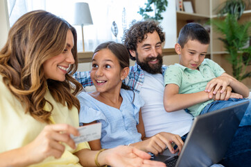 Mother holding credit card to complete online shopping purchase with family