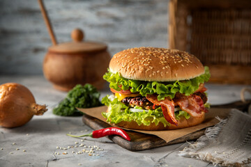 Homemade hamburger with bacon and chili pepper on the table