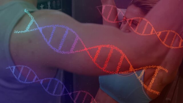 Adult woman reaching lat pulldown bar, pulling reps with animated DNA overlay highlighting fitness