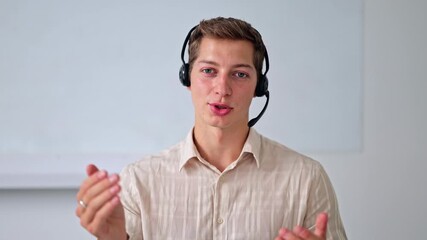 Professional man in a striped shirt, wearing a headset, enthusiastically communicates in a modern office. His cheerful demeanor and clear speech convey excellent customer support.