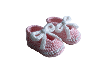 Pair of crocheted baby shoes, pink with white accents.  Tiny,  soft, and delicate.  Features a white bow on each.  Handmade