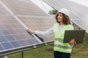 Female engineer inspecting solar panels in a solar power plant