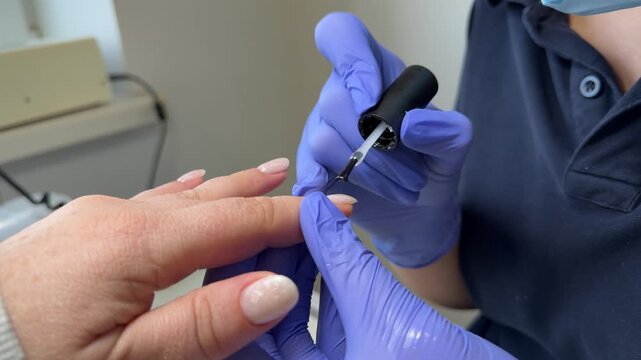 Nail acetone removal stock video footage of manicurist applying based primer dehydrator bond to manicured nails to help promote adhesion. Doing professional beautiful naildesign at beauty studio