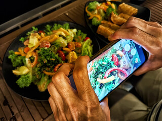 Capturing the vibrant colors of a fresh salad in a cozy outdoor setting at night with delicious side dishes