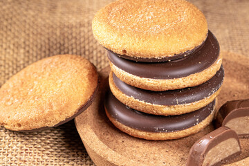 Delicious stack of chocolate cookies piled on a rustic burlap napkin