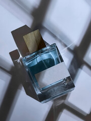 Perfume Bottle on White Table with Artistic Shadows