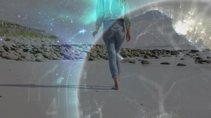 Woman walking along beach causing digital globe intensifying and illustrating tech connectivity - Powered by Adobe
