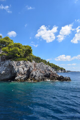 Beautiful Greek island landscape with lush, thick woodland and turquoise tropical waters. Mountains, dense green forests, white rocks and clear blue waters make up the idyllic travel destination.