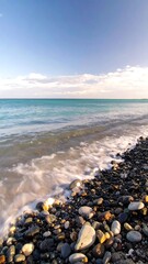 Coastal pebbles and waves at sunrise