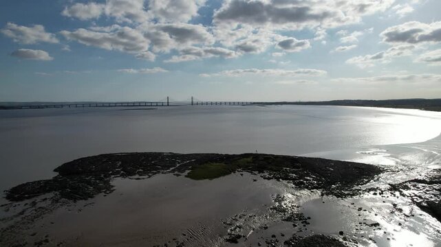 Drone view of St Tecla Chapel ruins silhouetted on a tidal island under dramatic light