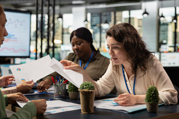Goals oriented businesswomen representing strategic collaboration in the office, using tablet and data reports to build strong goals alignment and inspire achievement across company.