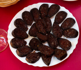 Sliced pieces of burgos blood sausage served on platter..
