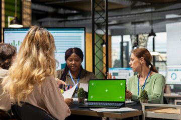 Group of empowered professionals work with green screen on laptop in modern office work environment, embodying a corporate feminism mindset and vision for growth. Empowerment.