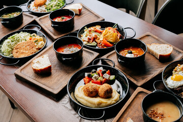 Assorted traditional European meals with soups, salads, and main courses on wooden trays