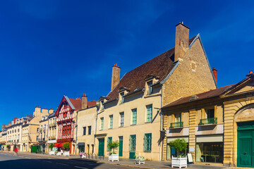 Naklejka premium Picturesque summer cityscape of Dijon overlooking narrow street with typical residential townhouses , France.