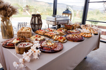 Buffet spread featuring various appetizers and pastries at a scenic outdoor location during a daytime event