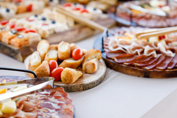 Variety of gourmet appetizers served on wooden platters at a festive outdoor gathering during summer
