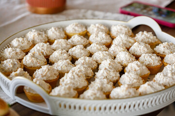 Delicious pastry desserts topped with cream on a decorative platter at a gathering