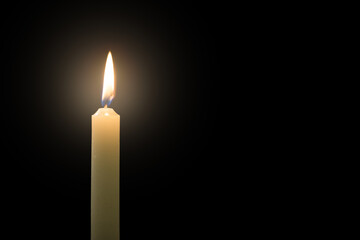 White thin candle on a black background, close up shot. Grief, loss, and mourning concepts.