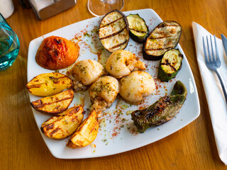 Grilled cuttlefish with grilled vegetables - eggplant, peppers and tomatoes on a plate