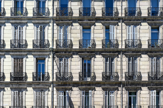 Elegant Haussmann-style apartment building with ornate wrought iron balconies and open windows, geometric symmetry, Place Castellane, Square, Marseille, France