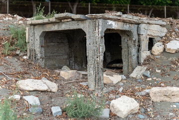 Abandoned concrete structure on the street in Limassol, Cyprus. Old shelter among stones and dry grass.  © Artur Studio