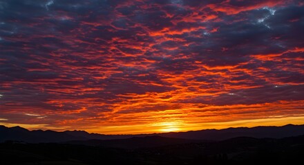 Obraz premium Fiery orange sunset paints the horizon. Dramatic skyscape is perfect for travel blogs, nature photography, or atmospheric backdrops.