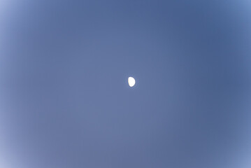 Moon in the evening sky over Cyprus. Astronomical landscape against the blue sky.
